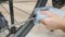 Cleaning bicycle chain. Bike maintenance. Bicycle workshop. Bicycle mechanic cleans bike chain with blue microfibre cloth. Repairi