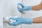 Cleaning black door handle with an antiseptic wet wipe, blue gloves and sanitizer. Sanitize surfaces prevention in