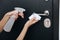 Cleaning black door handles with an antiseptic wet wipe. Woman hand using towel for cleaning home room door link