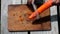 Cleaning carrot with knife on wooden board