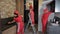 cleaning company employees in red uniforms are cleaning the kitchen in the apartment