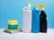 Cleaning concept with various plastic bottles canisters and sponges on blue background. Various detergents and the necessary