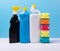 Cleaning concept with various plastic bottles canisters and sponges on blue background. Various detergents and the necessary