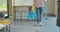 Cleaning concept. Woman with floor mop and bucket with washing fluids, back view.