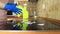 Cleaning cooktop cooking panel in kitchen with fat remover spray and a duster by a woman in yellow rubber gloves