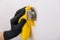 Cleaning door handle with yellow wipe in black gloves. Woman hand using towel for cleaning. Disinfection in hospital and