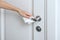 Cleaning door handles with an antiseptic wet wipe and gloves. Woman hand using towel for cleaning home room door link