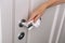 Cleaning door handles with an antiseptic wet wipe and gloves. Woman hand using towel for cleaning home room door link