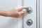 Cleaning door handles with an antiseptic wet wipe and gloves. Woman hand using towel for cleaning home room door link