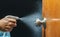 Cleaning door knob with alcohol spray for  Covid-19 Coronavirus prevention