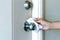 Cleaning door knob, hand use alcohol clean pad wiping  door knob before entering the room of building for disinfect virus bacteria