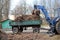 Cleaning dry branches and grass on city streets loading into truck trailer.