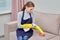 Cleaning of furniture with household chemicals. Girl with gloves.