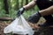 Cleaning garbage in bags in the park. Close-up of a volunteer collecting plastic waste. World cleaning or Earth day, Generative AI