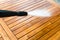 Cleaning garden acacia table with a power washer - high water pressure cleaner on wooden exotic table surface  - focus on the tip