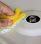 Cleaning the gas stove. foam scouring sponge. male hand. the top is the dirty surface of the gas stove.