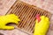 Cleaning the grill. Hands in yellow gloves clean the dirty grill of grease and burns with a cleaning agent. electric grill hygiene