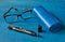 Cleaning handle for optics, glasses and glasses case on blue background, close up