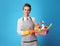 Cleaning lady with basket with detergents and brushes on blue