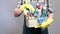 a cleaning lady holds a plastic bucket with detergents, brushes, sponges and rubber gloves for cleaning the premises