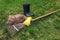 Cleaning lawn from dry grass with a rake in spring garden. Heap of grass with boots and tool