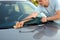 Cleaning like a professional- man cleaning his car with a microfiber cloth .