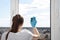 Cleaning after repair, facade cleaning. Young girl washes a window with a sponge