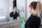 Cleaning service in the bathroom of an expensive hotel. A woman in uniform cleans the frame of the mirror. The concept of