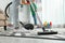 Cleaning service professional vacuuming carpet indoors