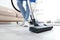 Cleaning service professional vacuuming floor with hoover