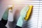 Cleaning shutters with a detergent closeup. hands in green rubber gloves washing silver metal blinds with a yellow rag