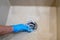 Cleaning the sink drain with blue rubber gloves. Cleaning solid surface sink. Housework concept.