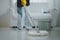 Cleaning staff mopping floors at home Wear an apron and rubber gloves to protect against cleaning chemicals. Use a mop to clean