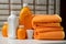 Cleaning supplies Orange liquid washing powder with neatly folded towels on shelf