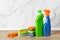 Cleaning supplies for routine household chores against marble wall. Copy space. Two bottles with liquid detergent, foam sponges,