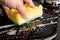 Cleaning the surface on a black gas stove yellow washcloth close-up, cleaning the kitchen, appliances