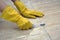 Cleaning tile joints with a toothbrush. Yellow household gloves