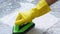 Cleaning the tiled floor with a green color plastic floor scrubber.