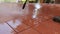 Cleaning the tiles on the patio floor with a high pressure cleaner
