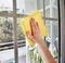 cleaning a window with yellow cloth