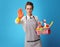 Cleaning woman with a basket with cleansers and brushes showing