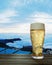 Clear beer glass with full cold beer and foam at the mouth of the glass And water droplets adhere to the edges. Plank or wood