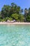 Clear blue sea and beach with palm trees. View from the sea to the Thailand beach, large stones on the shore and clean sand