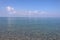 The clear blue sea. Clear sky. Sunny morning. Clouds are reflected in the water. Calm. Calabria, coast of the Tyrrhenian Sea.