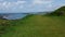 Clear blue sea before the grassy hill on Puffin Island Lunga in Scotland