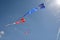 Clear blue sky filled with different colorful kites. One is a canadian flag kite.