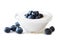 Clear bowl of yogurt with blueberries over white