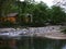 The clear creek in the forest, the wooden house next to the creek