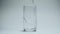 Clear drinking water pours into a clean transparent glass on a white background.