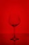 Clear empty wine glass isolated on red